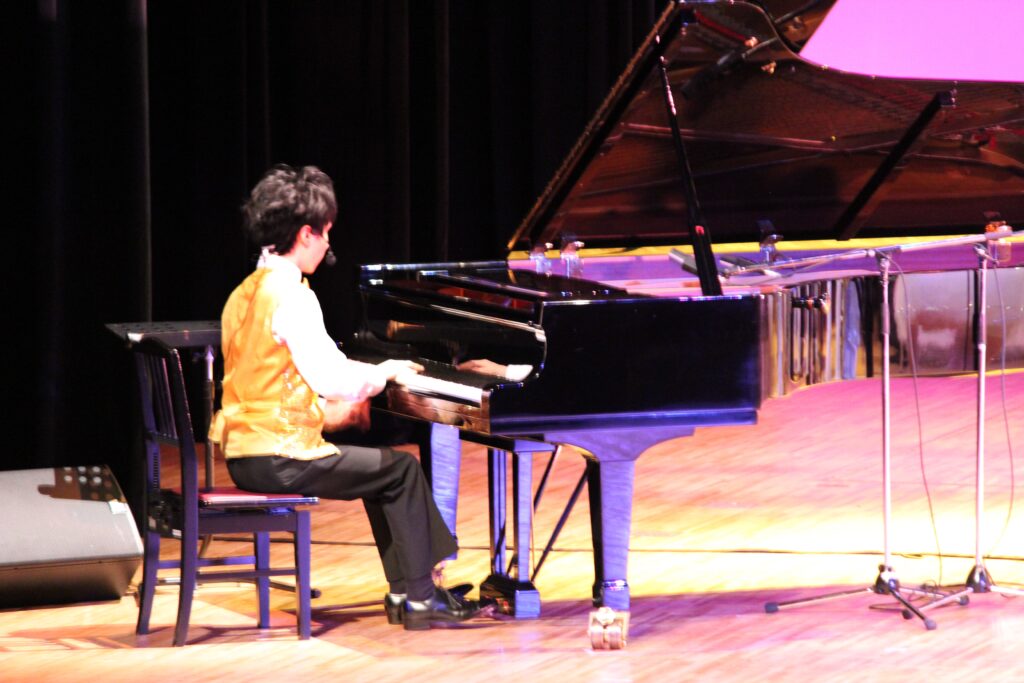 ステージでピアノを演奏している写真です